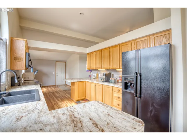 a kitchen with stainless steel appliances granite countertop a refrigerator and a sink
