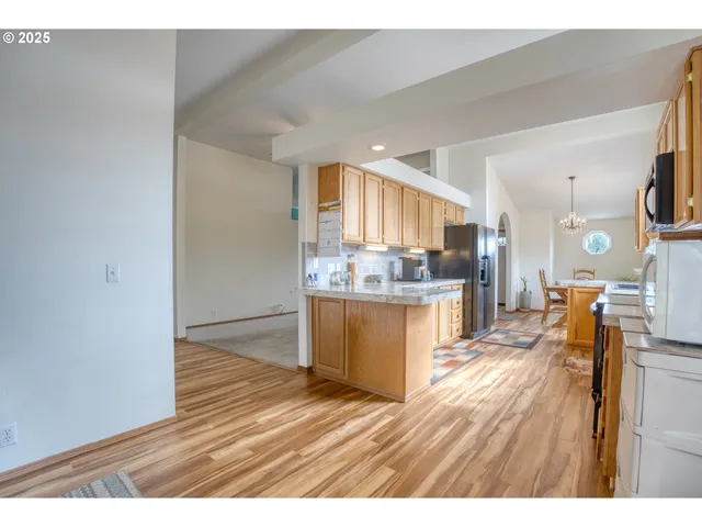 a kitchen with stainless steel appliances wooden floor dining table and chairs