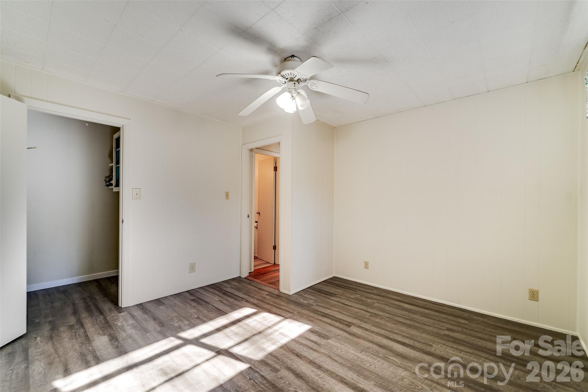 744 Coon Creek Road Franklin, NC 28734 - Photo 8 of 21 a view of a bedroom with wooden floor and a ceiling fan
