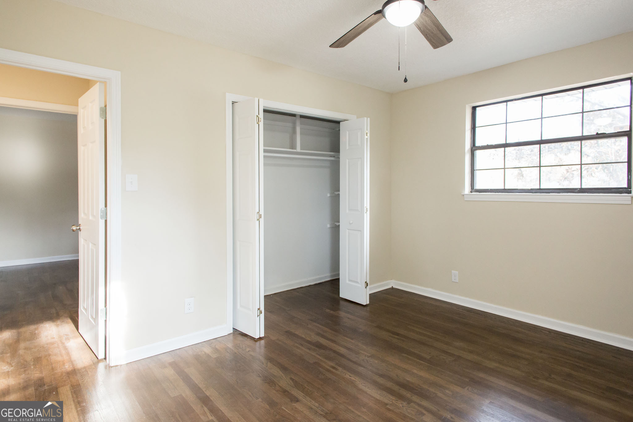 407 Pineview Drive Waycross, GA 31501 - Photo 22 of 35 an empty room with wooden floor chandelier and windows