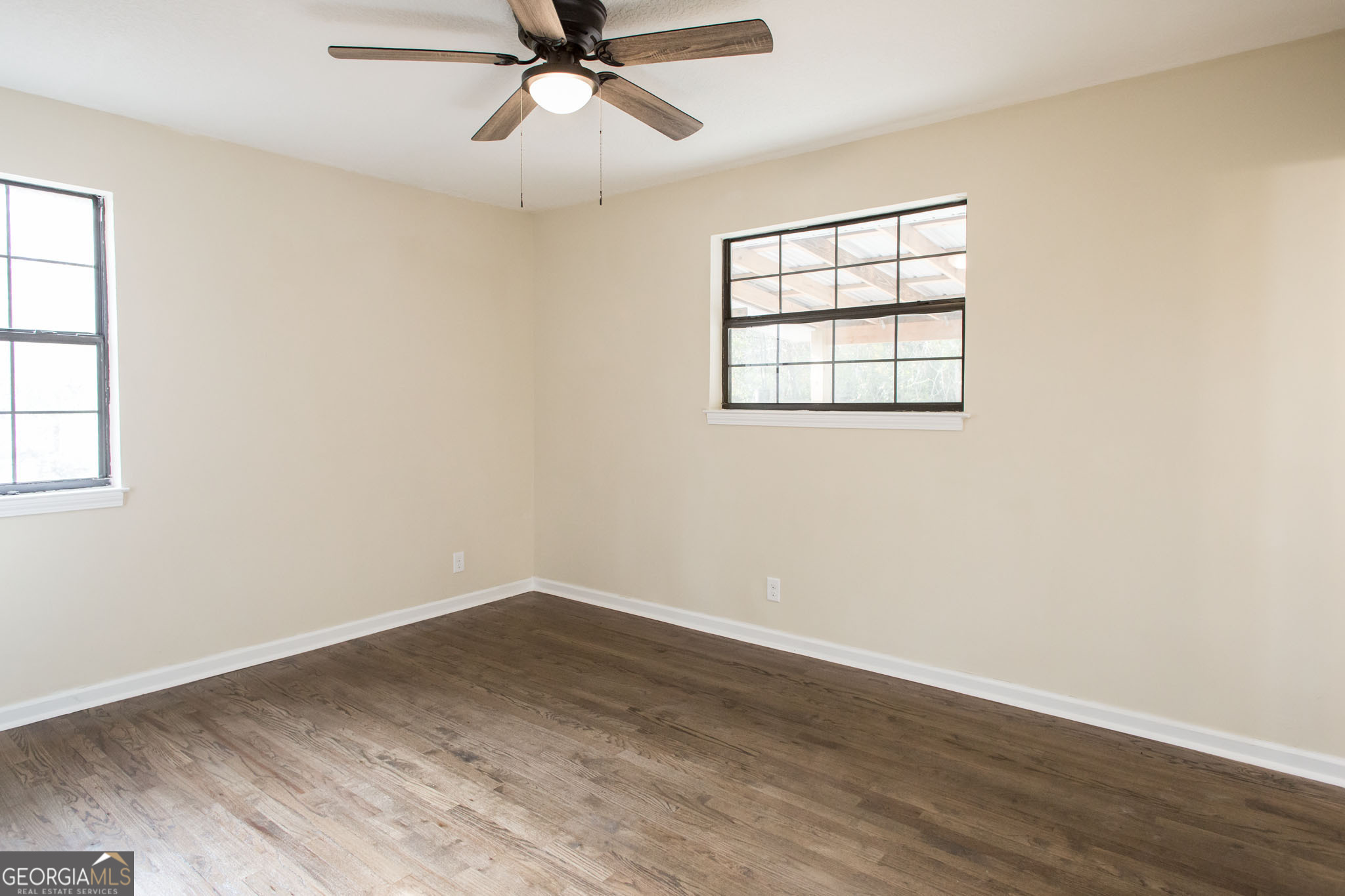 407 Pineview Drive Waycross, GA 31501 - Photo 23 of 35 an empty room with wooden floor fan and windows