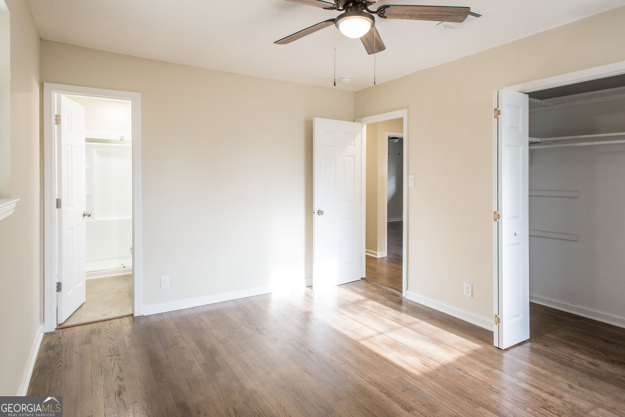 407 Pineview Drive Waycross, GA 31501 - Photo 24 of 35 an empty room with wooden floor fan and windows