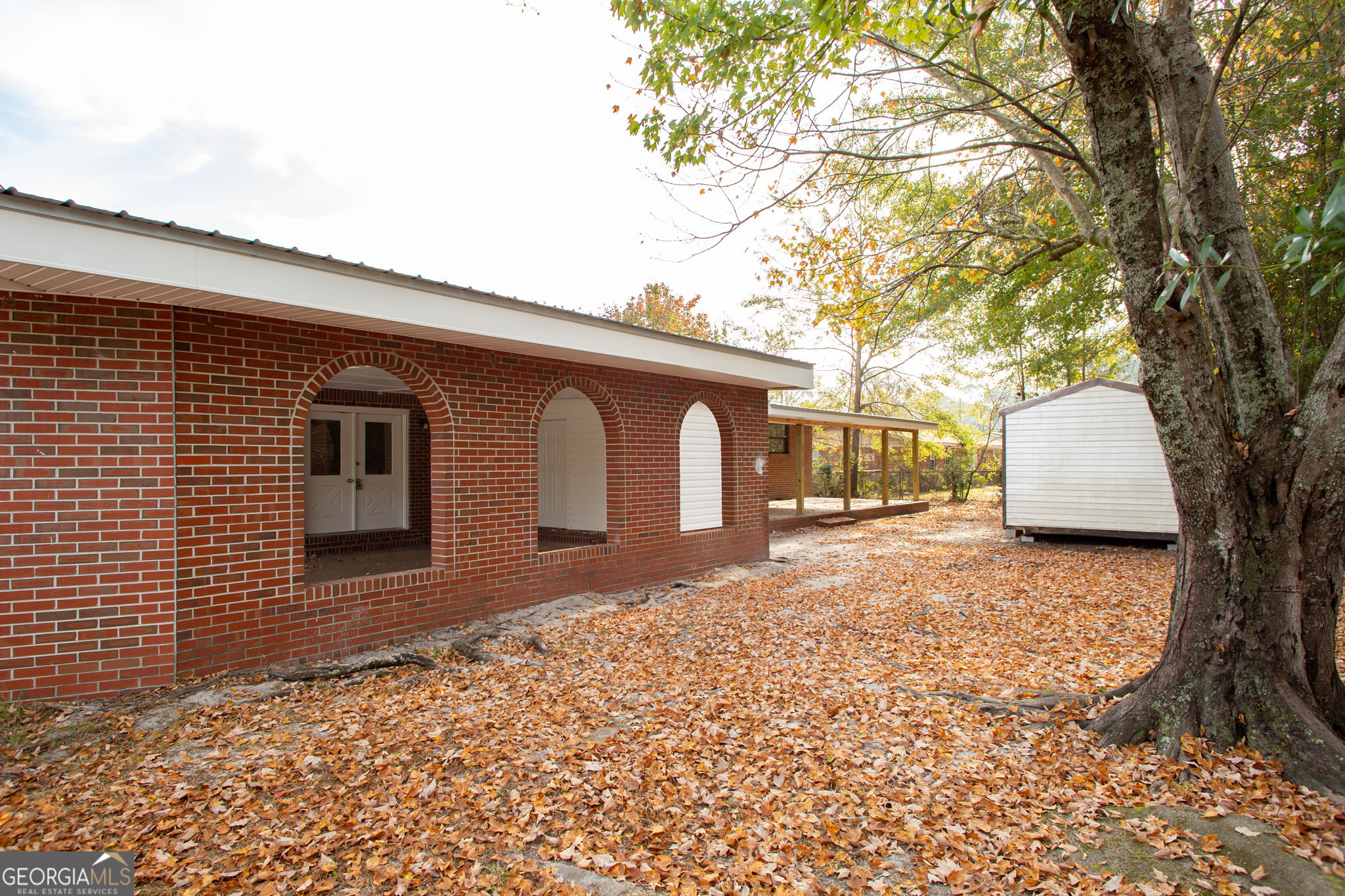 407 Pineview Drive Waycross, GA 31501 - Photo 33 of 35 a backyard of a house with large trees and wooden fence