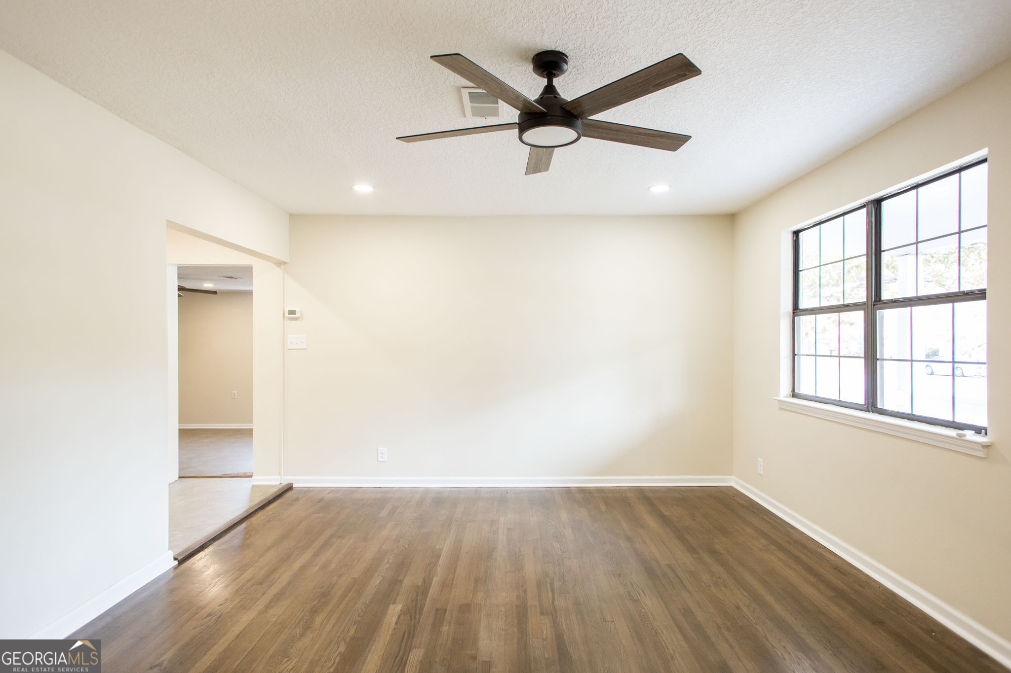 407 Pineview Drive Waycross, GA 31501 - Photo 5 of 35 an empty room with wooden floor and windows