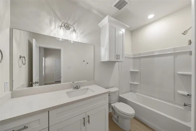 a bathroom with a sink a toilet a mirror and shower