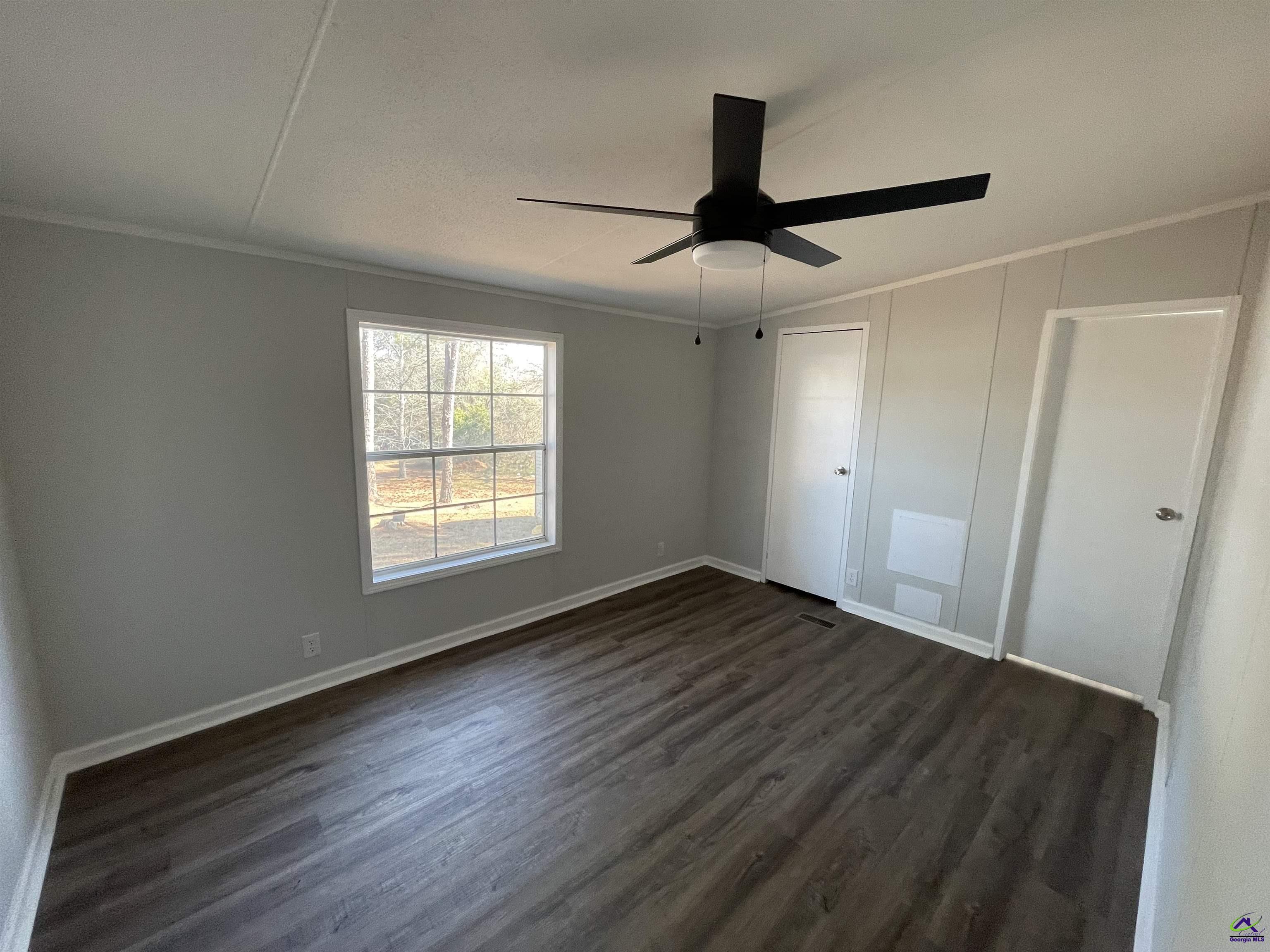 306 Dennard Road Unadilla, GA 31091 - Photo 14 of 14 a view of an empty room with wooden floor and a window