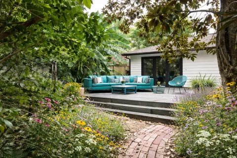 a view of a house with fountain plants and large trees