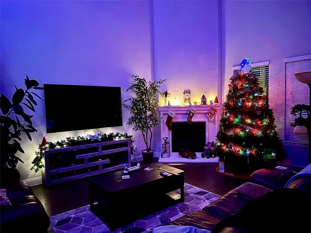 a living room with furniture a flat screen tv and a fireplace