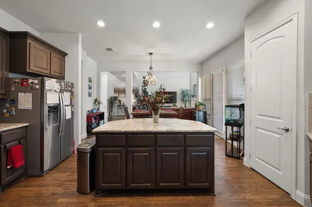 a large kitchen with stainless steel appliances granite countertop a sink refrigerator and cabinets