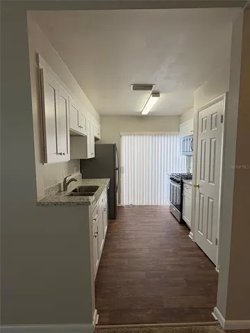 a kitchen with granite countertop a sink and a stove top oven