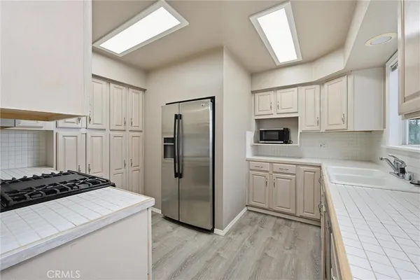 a kitchen with white cabinets and stainless steel appliances