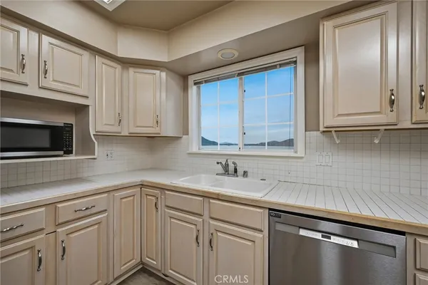 a kitchen with stainless steel appliances granite countertop a sink a stove and cabinets