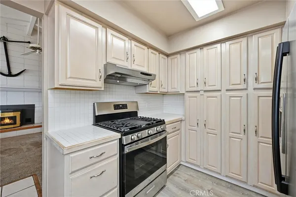 a kitchen with white cabinets and a stove top oven