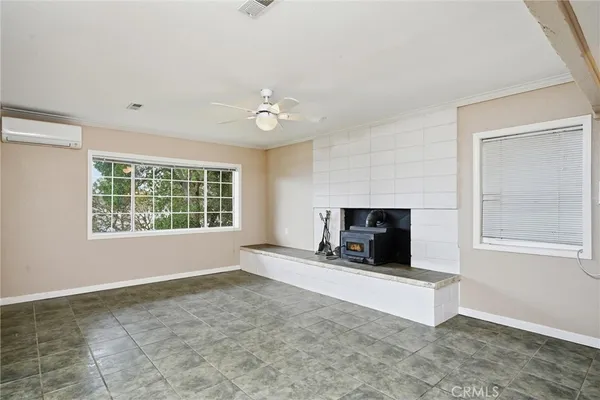 a view of an empty room with a fireplace and a window