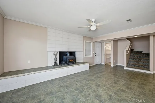 an empty room with a fireplace and a ceiling fan