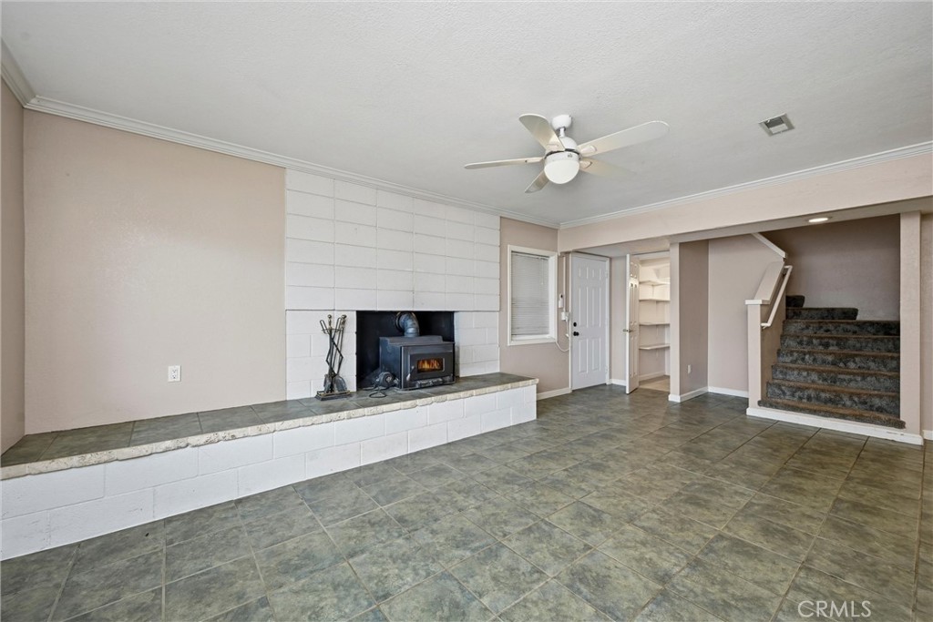 13674 Anderson Road Lower Lake, CA 95457 - Photo 24 of 38 an empty room with a fireplace and a ceiling fan
