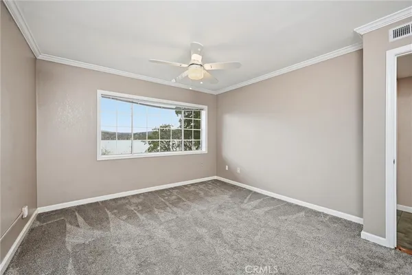 an empty room with windows and fan