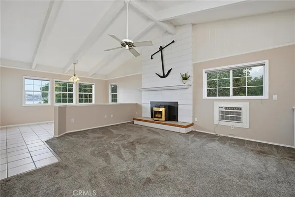 an empty room with windows and fireplace