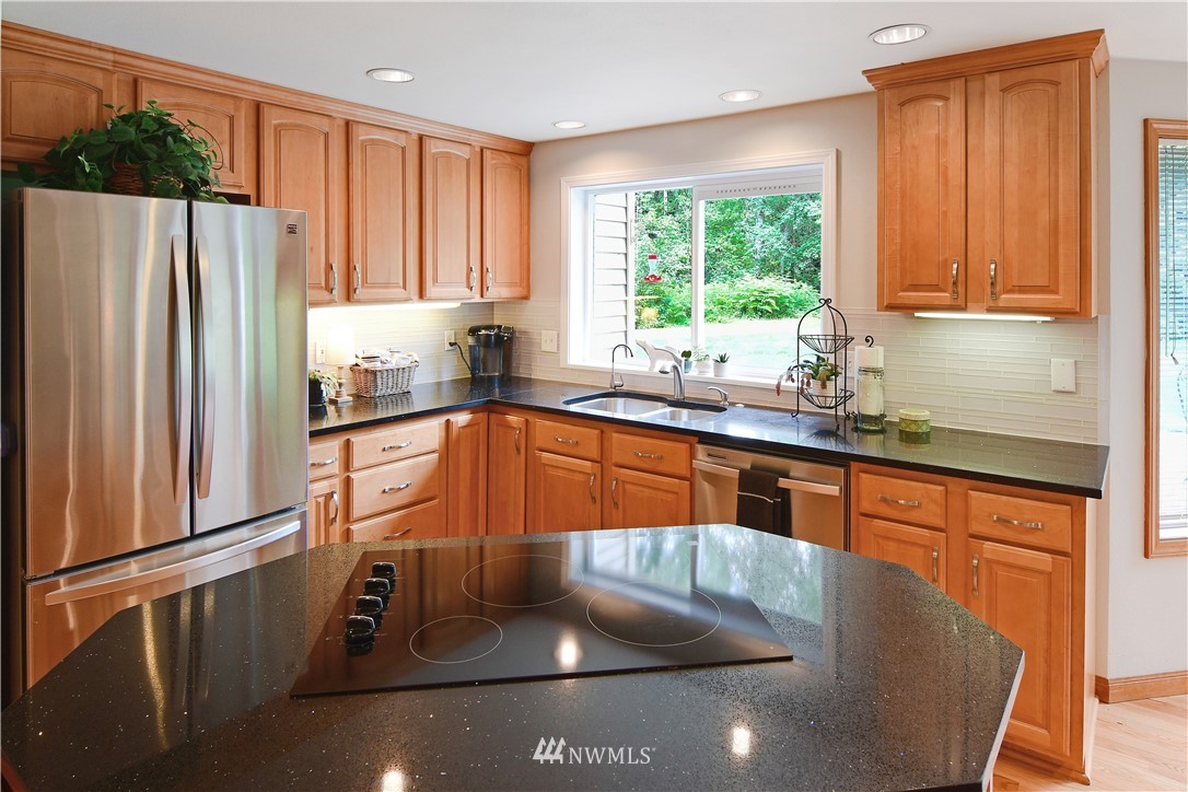 4025 204th Street Southeast Bothell, WA 98012 - Photo 11 of 35 a kitchen with stainless steel appliances granite countertop a sink a refrigerator and a granite counter tops with a large window