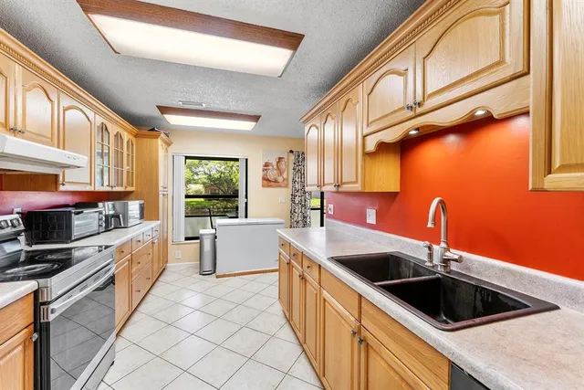 a kitchen with stainless steel appliances granite countertop a sink and a refrigerator