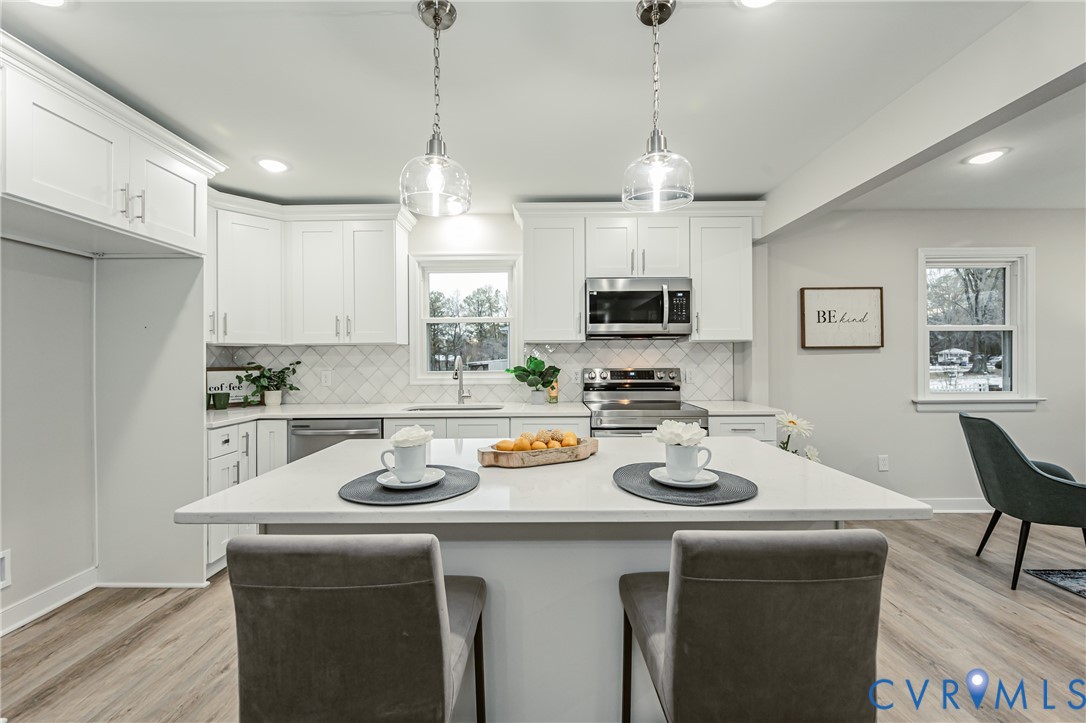 11251 Celtic Road Chesterfield, VA 23838 - Photo 14 of 49 a kitchen with stainless steel appliances granite countertop a sink a stove a dining table and chairs with wooden floor
