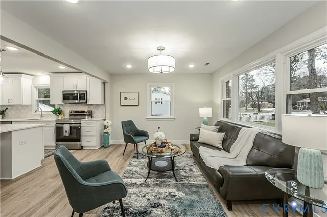 a living room with furniture a large window and a fireplace