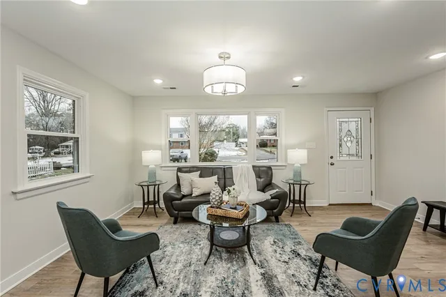 a living room with furniture a rug a lamp and a large window