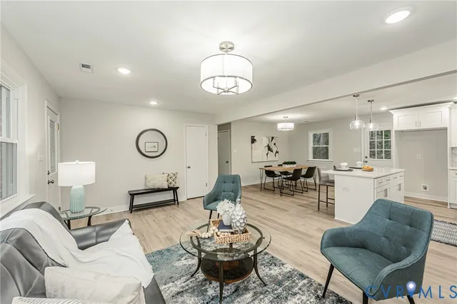 a living room with furniture kitchen view and a mirror