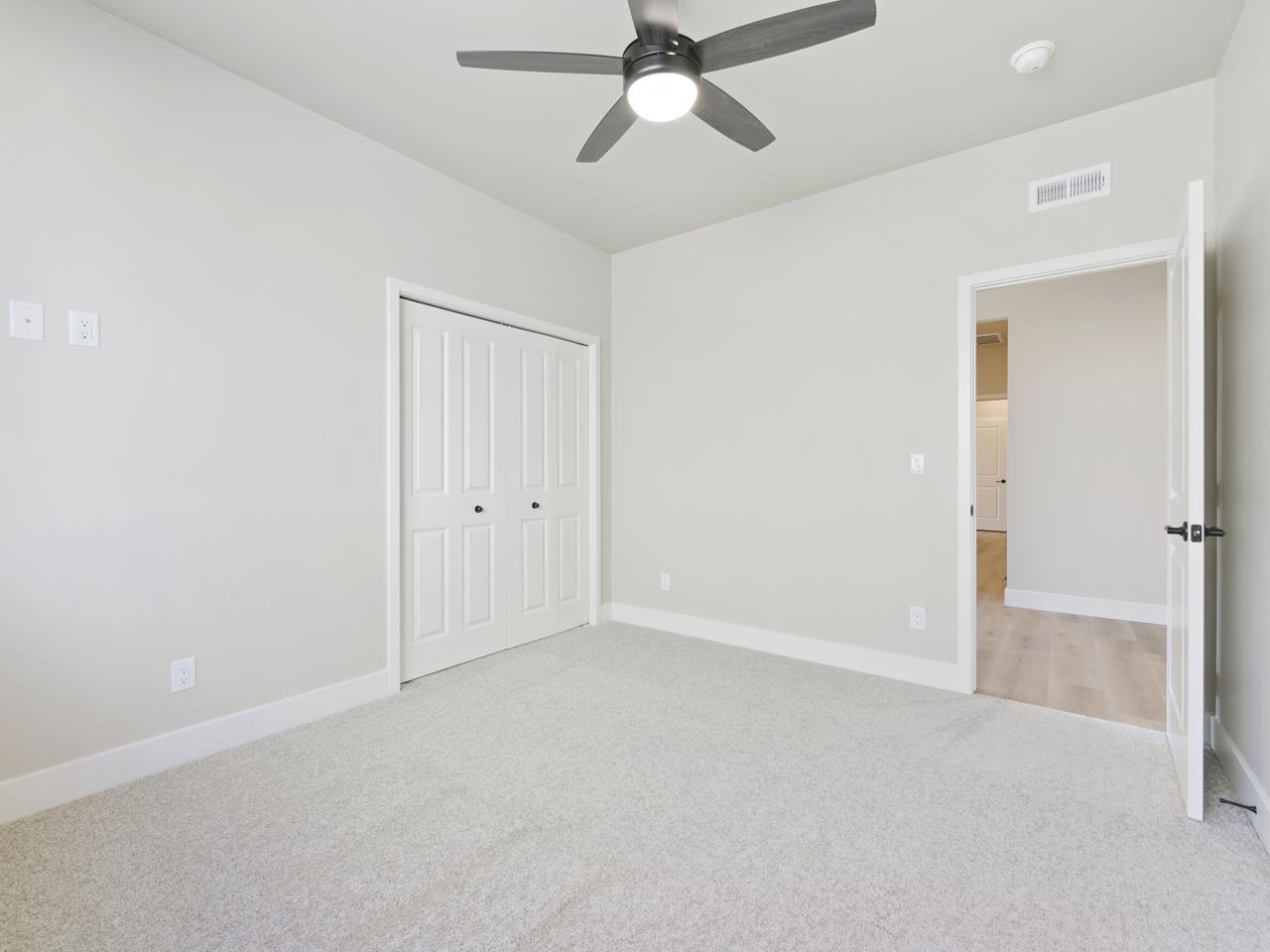 2267 Holy Cross Way Grand Junction, CO 81507 - Photo 28 of 36 an empty room with a ceiling fan and carpet