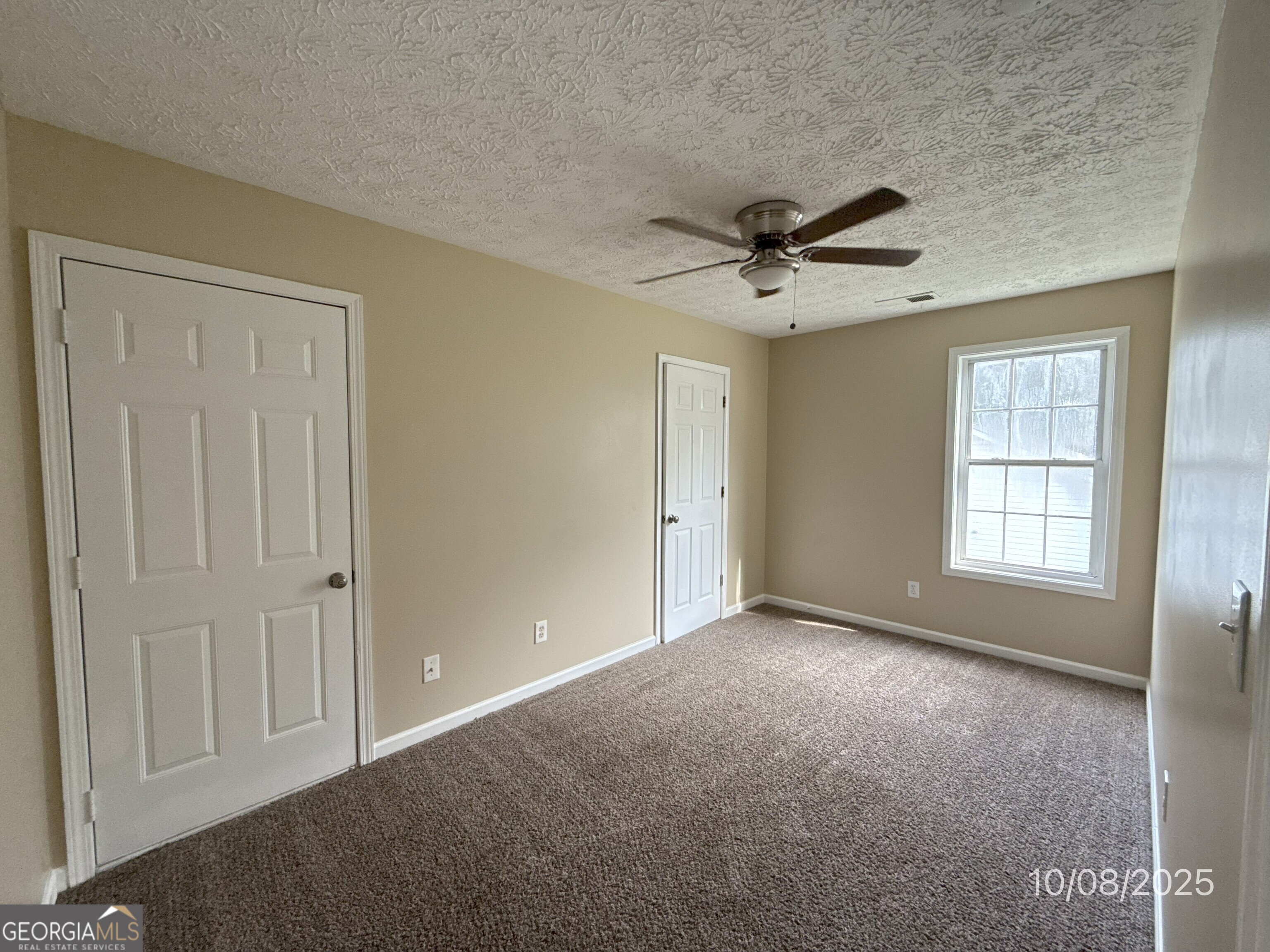 124 Waters Edge Drive Locust Grove, GA 30248 - Photo 12 of 13 an empty room with chandelier fan and windows