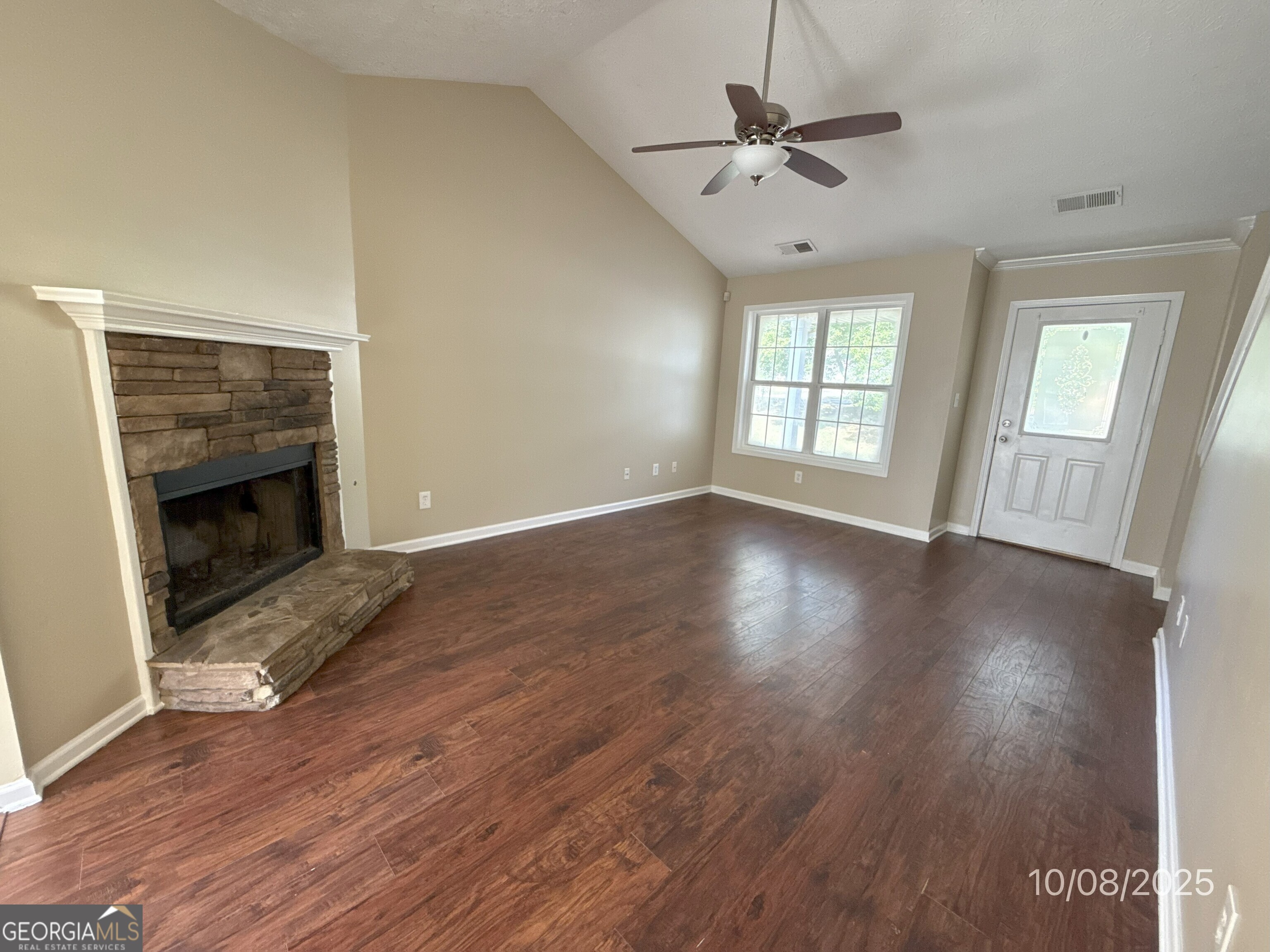 124 Waters Edge Drive Locust Grove, GA 30248 - Photo 2 of 13 an empty room with wooden floor a ceiling fan and a fireplace