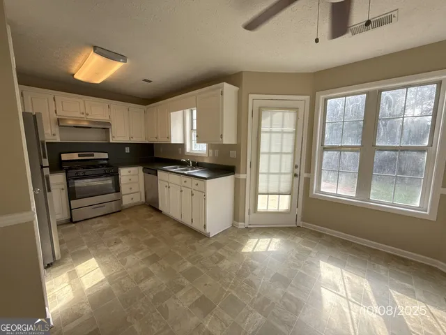a kitchen with stainless steel appliances granite countertop a stove a sink and a refrigerator