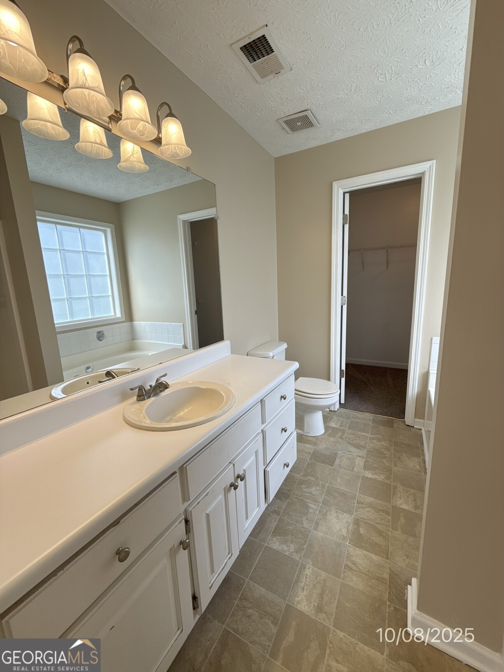 124 Waters Edge Drive Locust Grove, GA 30248 - Photo 9 of 13 a spacious bathroom with a double vanity sink and a mirror