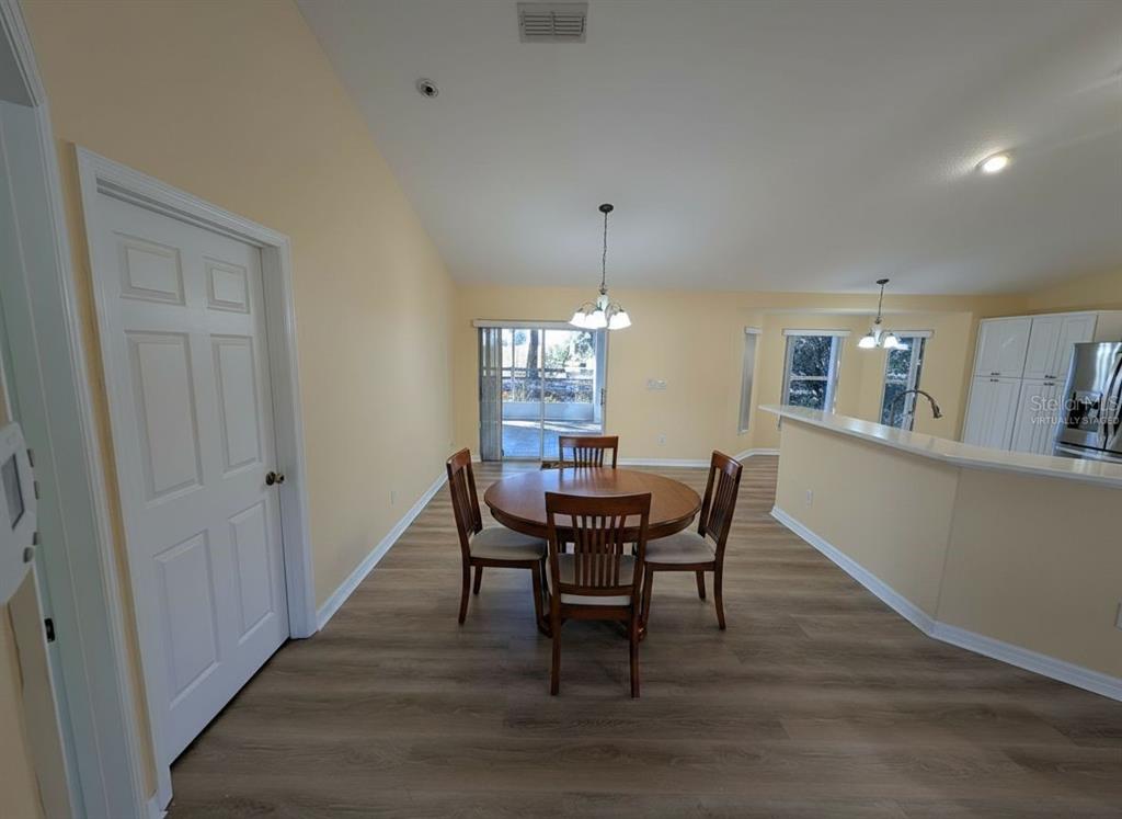 9573 Southwest 53rd Circle Ocala, FL 34476 - Photo 16 of 85 a dining room with furniture a chandelier and wooden floor