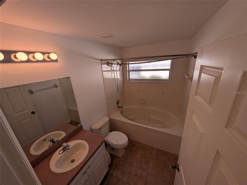 9573 Southwest 53rd Circle Ocala, FL 34476 - Photo 51 of 85 a bathroom with a granite countertop sink toilet a mirror and shower