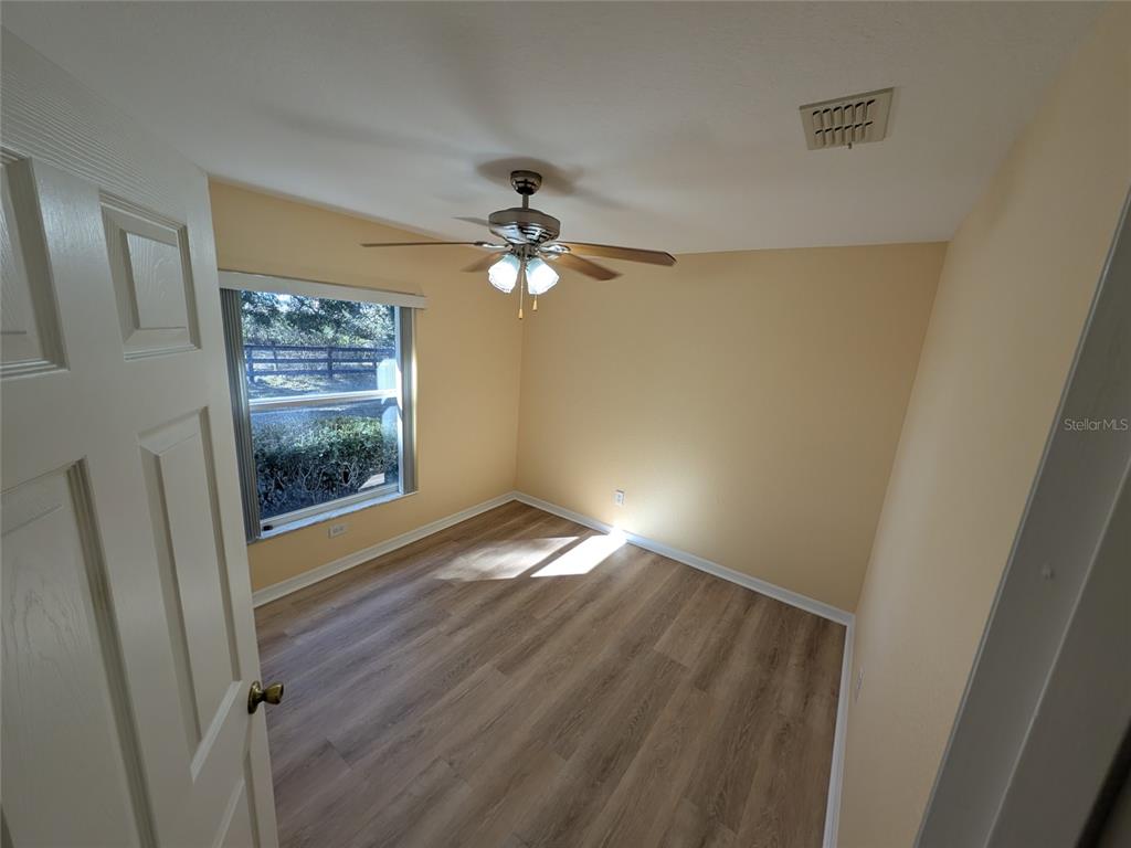 9573 Southwest 53rd Circle Ocala, FL 34476 - Photo 56 of 85 a view of an empty room with wooden floor and a window