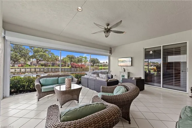 a living room with patio furniture and a floor to ceiling window