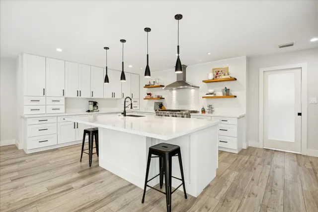 a kitchen with stainless steel appliances kitchen island hardwood floor sink and stove