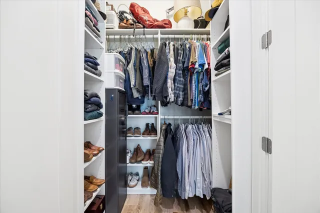 a view of walk in closet with clothes and shoes