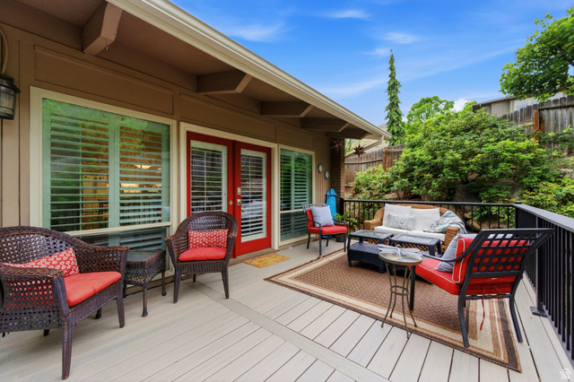 3674 Oak Rim Way Salt Lake City, UT 84109 - Photo 36 of 47 Spacious outdoor deck featuring light-colored decking, a black metal railing, and a red double French door entry