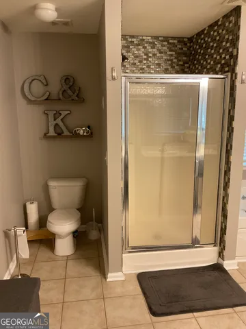 a bathroom with a toilet and a shower