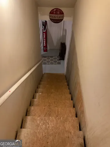 a hallway with stairs to other door