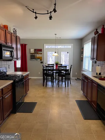 a view of a dining room kitchen with furniture and chandelier