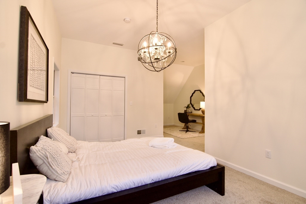 12 Rose Circle Hampden, MA 01036 - Photo 27 of 41 a bedroom with a bed and a chandelier