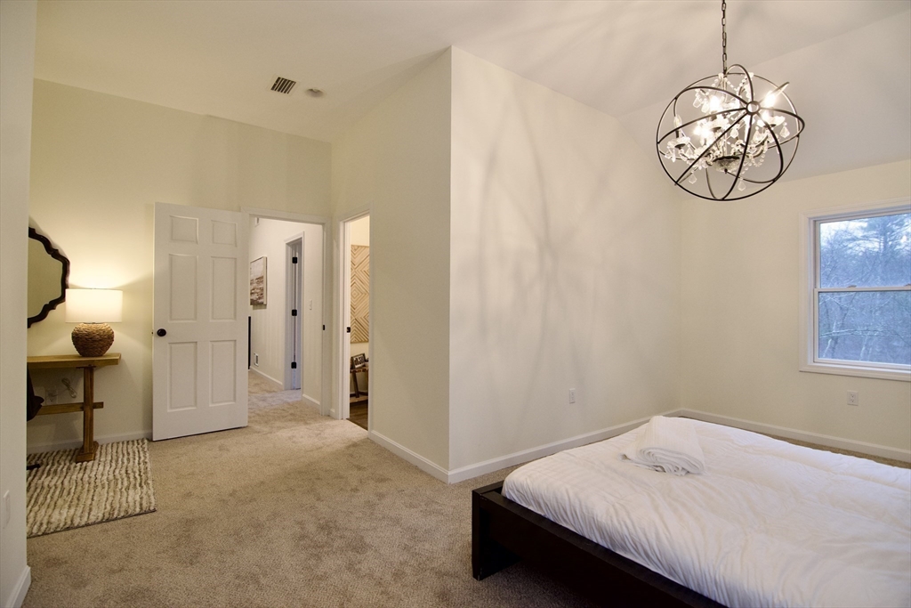 12 Rose Circle Hampden, MA 01036 - Photo 28 of 41 a bedroom with a bed and a chandelier