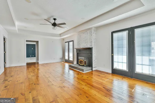 a kitchen with a refrigerator a stove a sink and white cabinets with wooden floor
