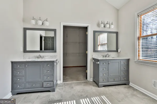 a view of an empty room with wooden floor and a fireplace