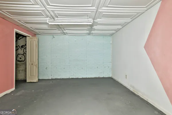 a view of a white house next to a yard with large trees