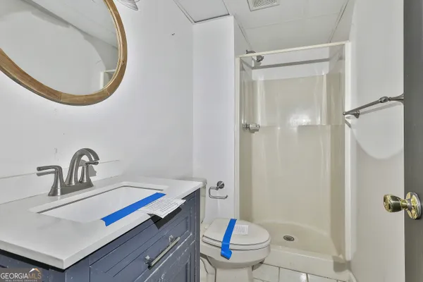 a view of a white house next to a yard with road and trees