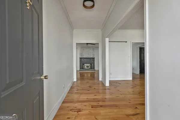 a view of empty room with wooden floor and windows